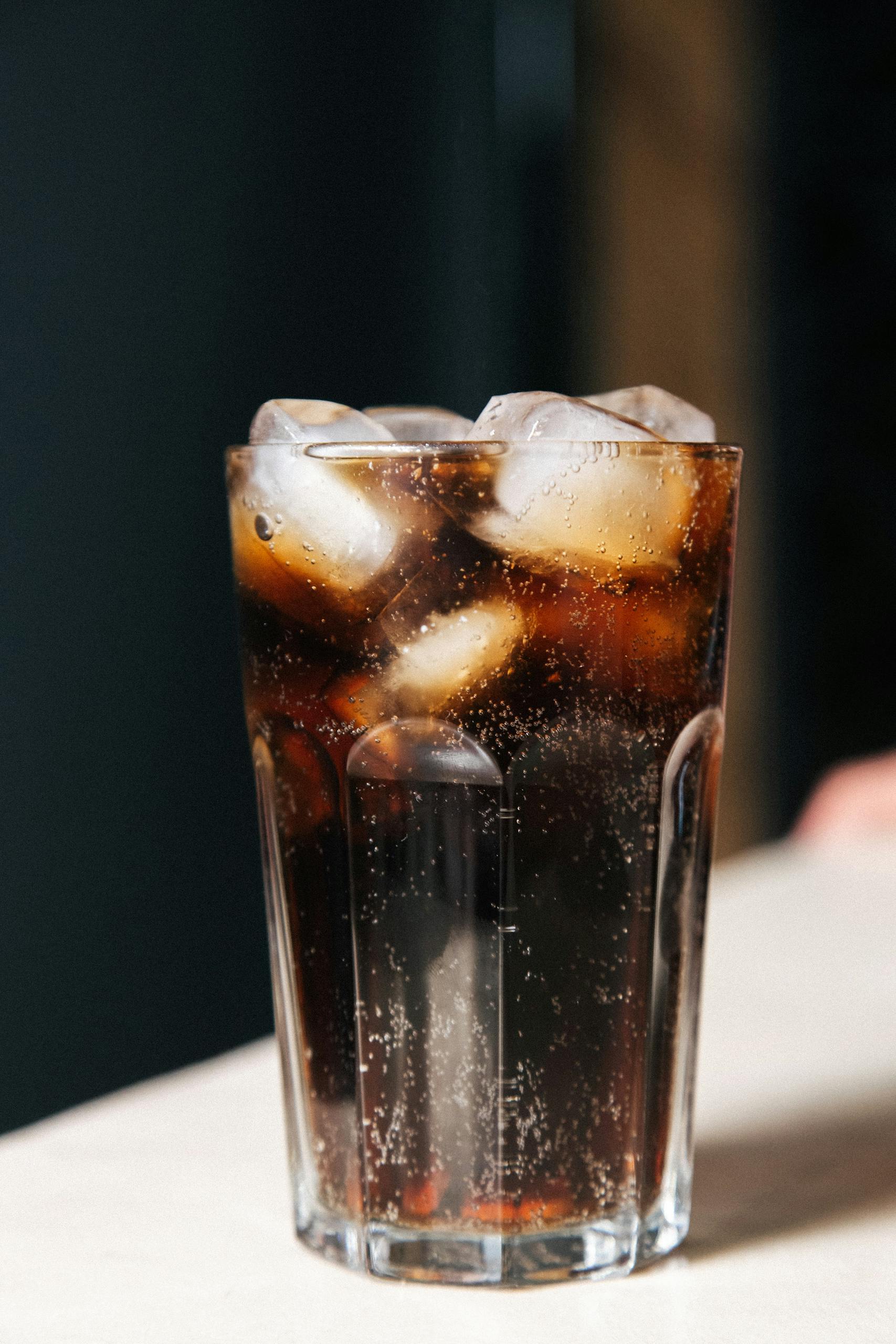 Sparkling soda with ice cubes in a glass, perfect refreshment.